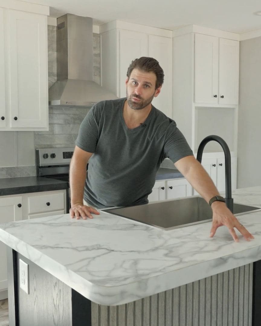 Kitchen island with marble-look countertop and a drop-in stainless steel sink