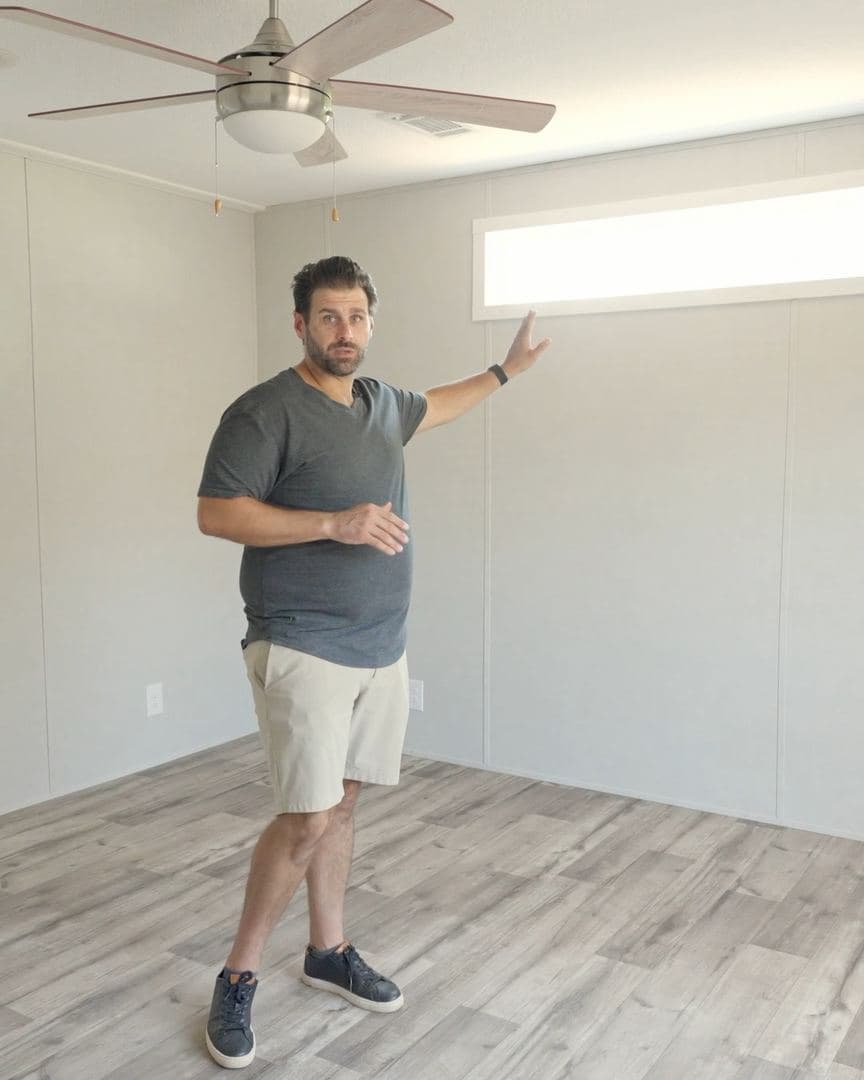 Primary bedroom with a transom window and ceiling fan