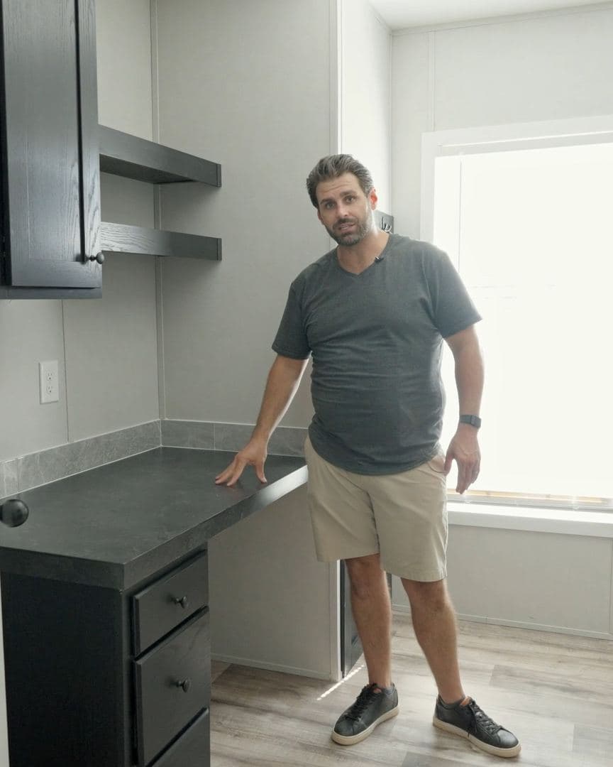 Utility room with a built-in desk, drawers, and floating shelves